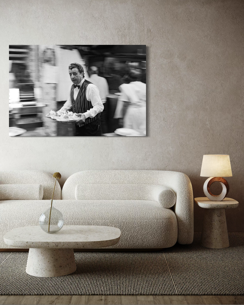 Czarno-biała fotografia na płótnie przedstawiająca kelnera w ruchu, niosącego tacę przez wnętrze restauracji, z rozmytym tłem i dynamiką chwili.